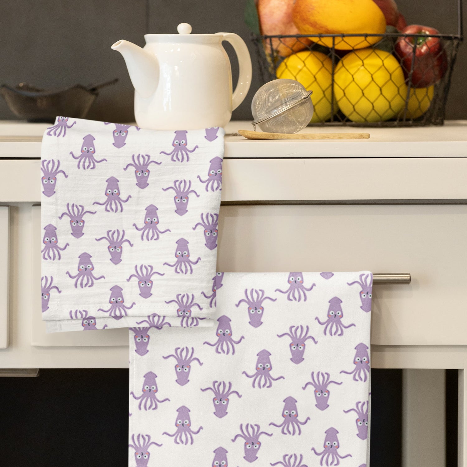 Purple Octopus design dish towels hanging in a modern kitchen.