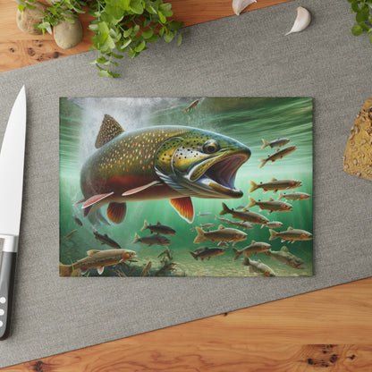 Brook Trout glass cutting board with vibrant fish design on a kitchen countertop.