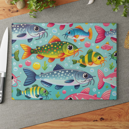 Vibrant catfish design on a glass cutting board displayed on a kitchen counter with a knife.