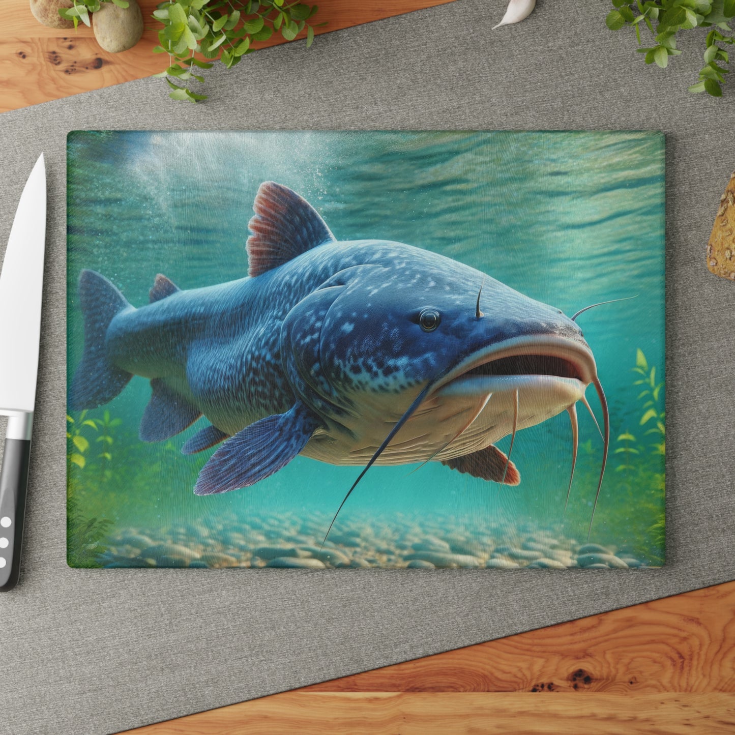 Vibrant Catfish Glass Cutting Board on kitchen counter with knife and greenery decor