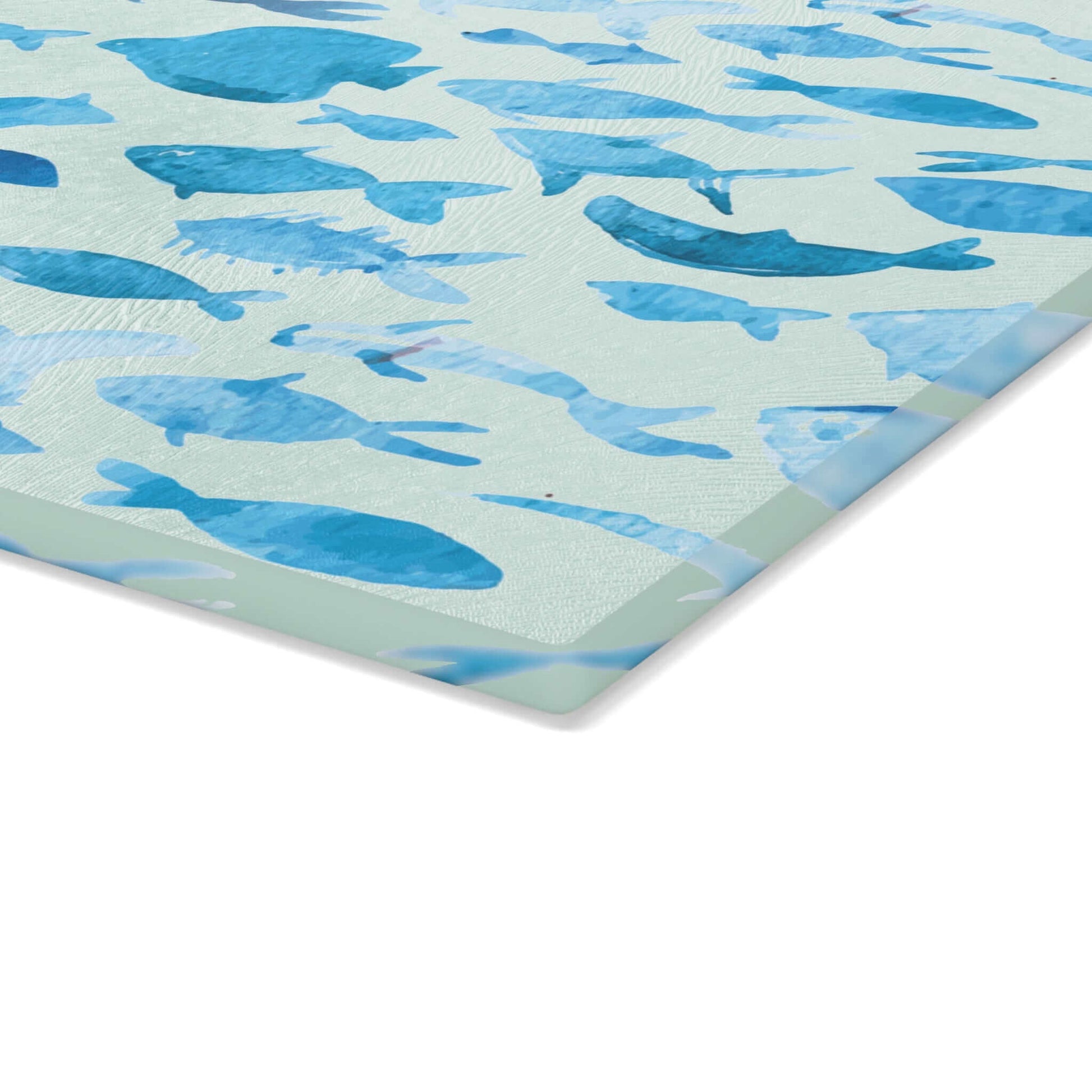 Blue watercolor fish design on tempered glass cutting board with non-slip padding