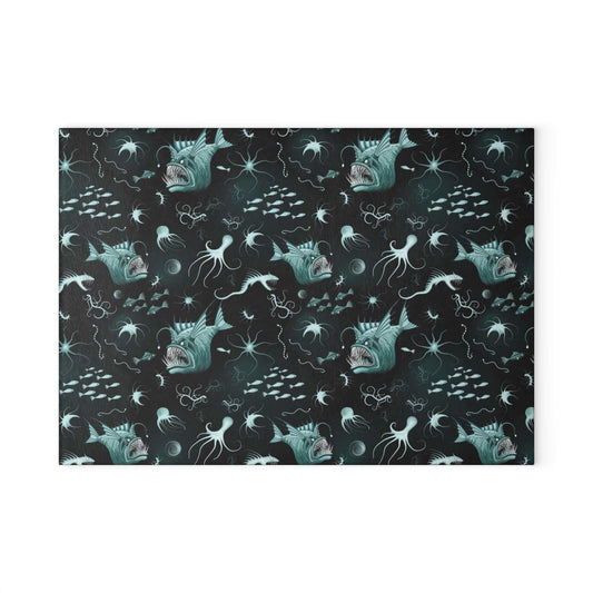 Anglerfish glass cutting board with marine life design and dark background.