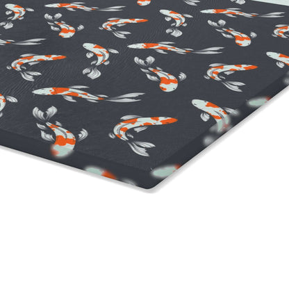 Colorful carp and koi fish on black glass cutting board with vibrant fish design.