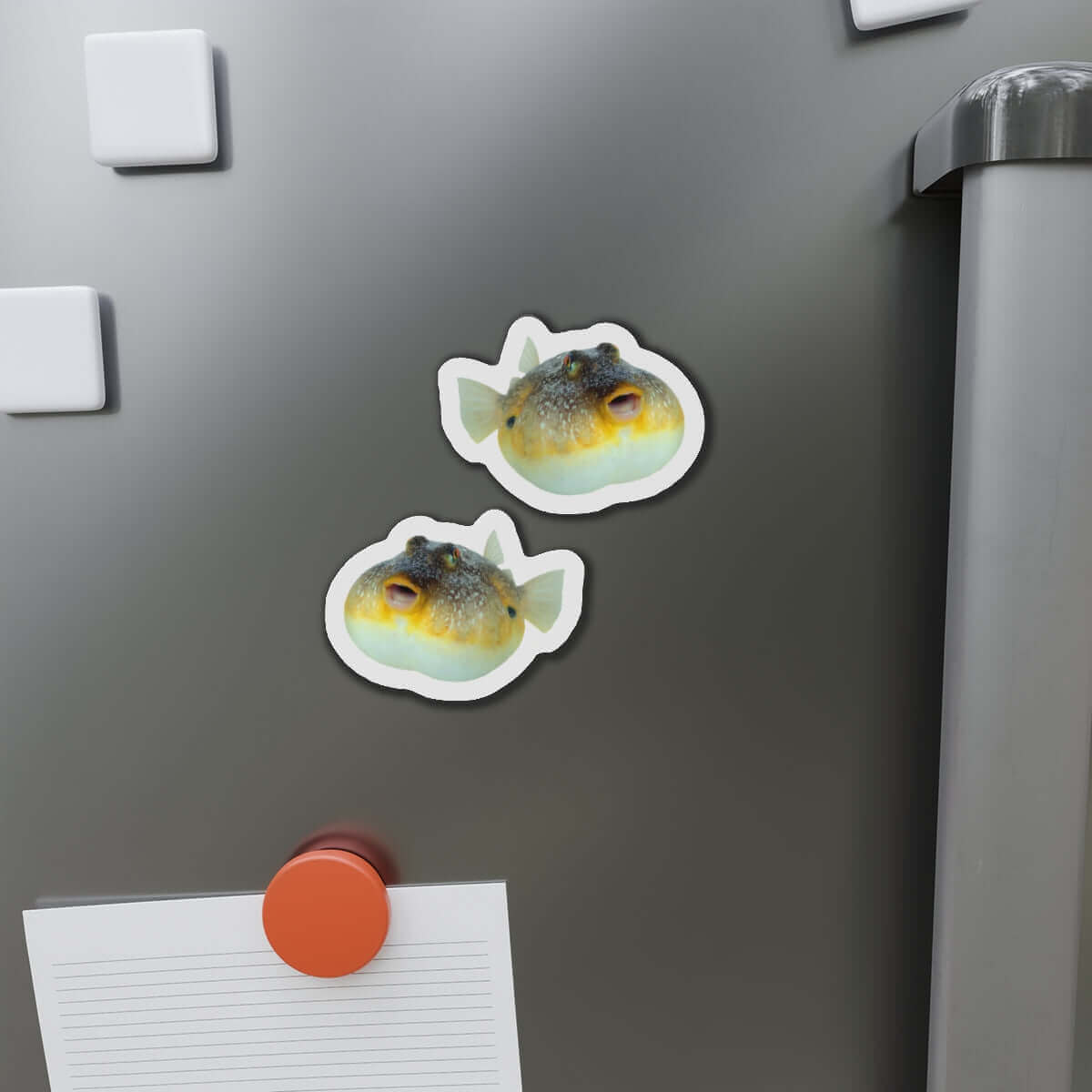 Pufferfish-shaped magnets on a refrigerator door, showcasing fun kitchen décor with a natural flair for fish fans.