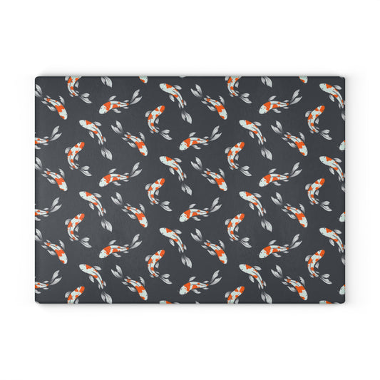 Carp and koi fish design glass cutting board with vibrant orange and white fish on a dark background.