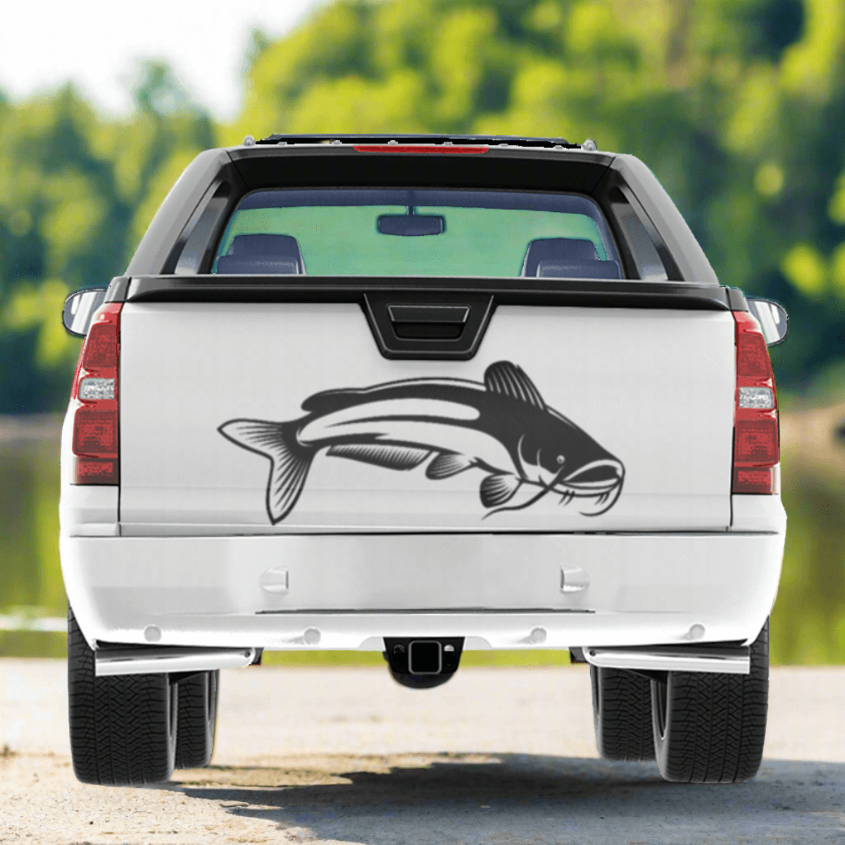 A large Catfish decal on a pickup truck near a river.