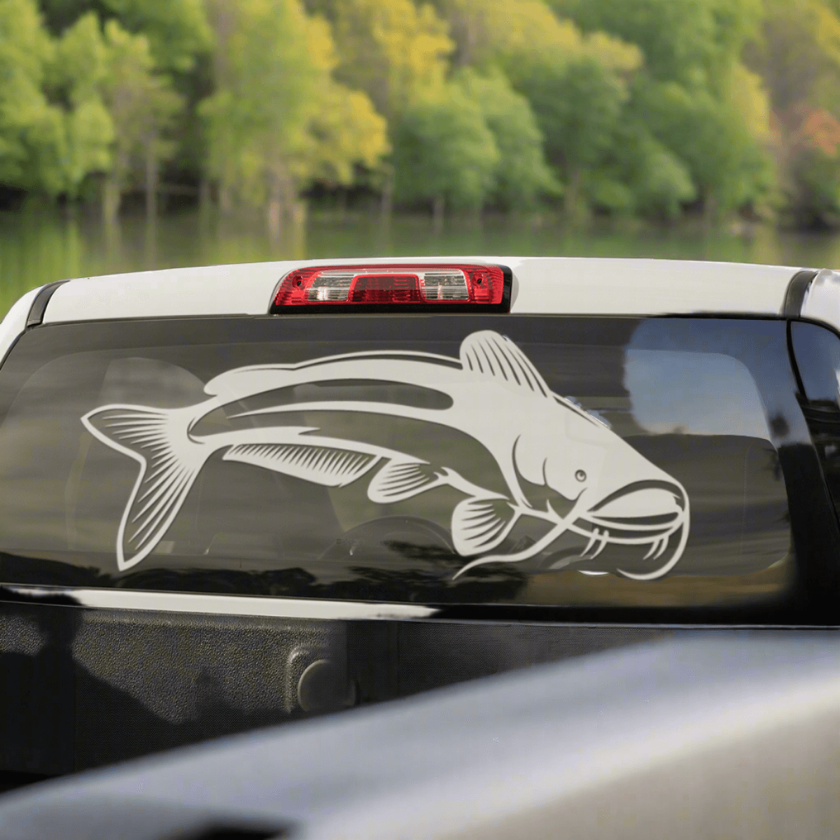 A large Catfish decal on a pickup truck window.