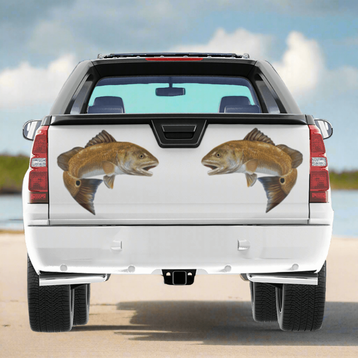 Red Drum, Redfish decals on a pickup truck parked by a saltwater estuary.