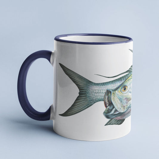 Tarpon accent mug with dark blue handle on light blue background.