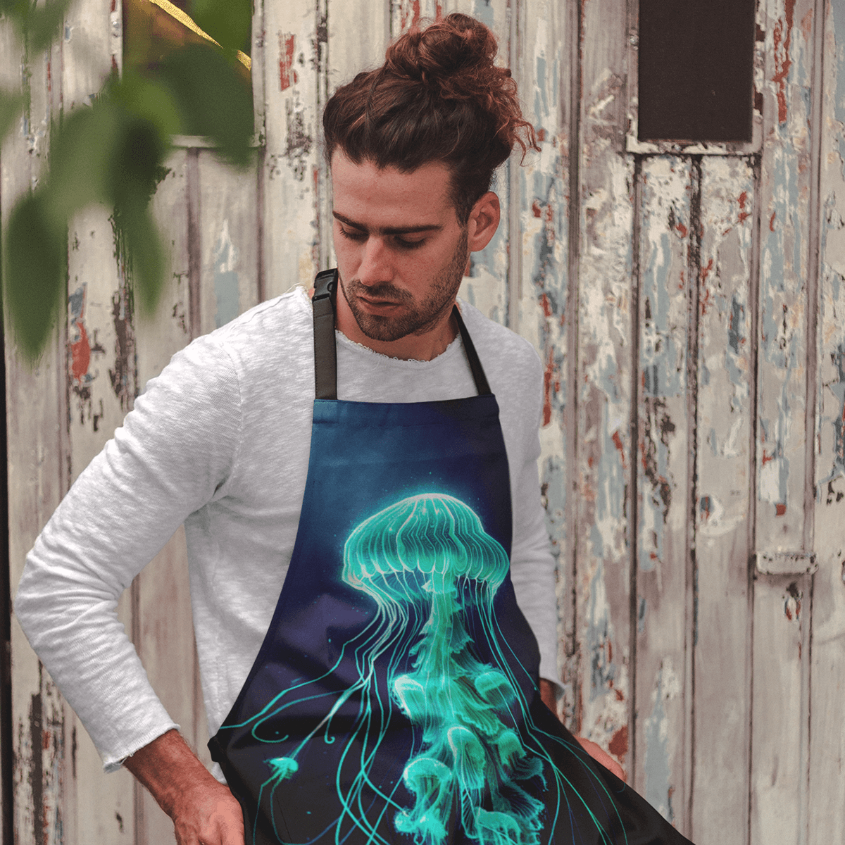 Person wearing apron with glowing green jellyfish design against wooden background