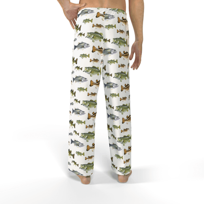 Man wearing pajama pants with colorful fish pattern, standing barefoot on a white background.