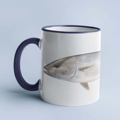 White mug with blue handle featuring a fish design, set against a light blue background.